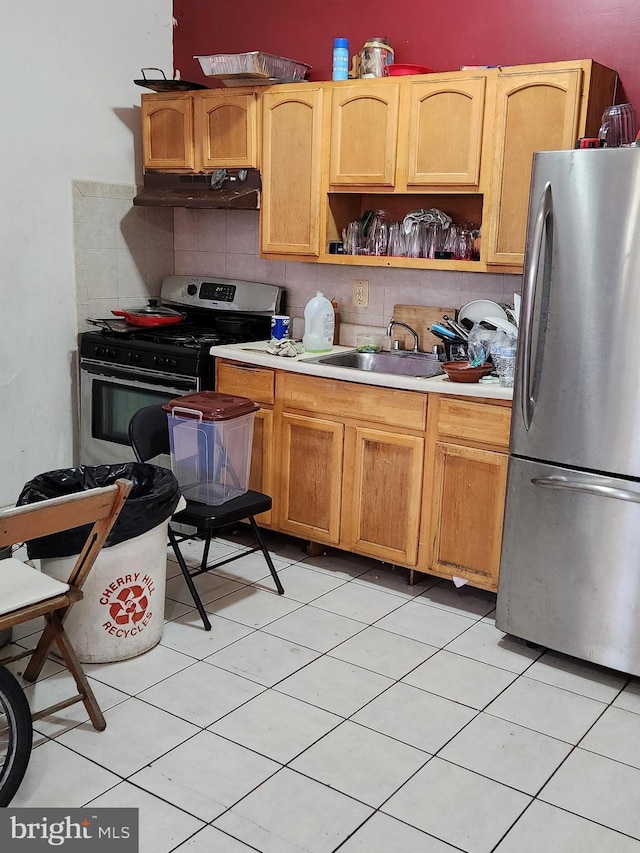 kitchen with tasteful backsplash, light tile patterned floors, sink, and stainless steel appliances