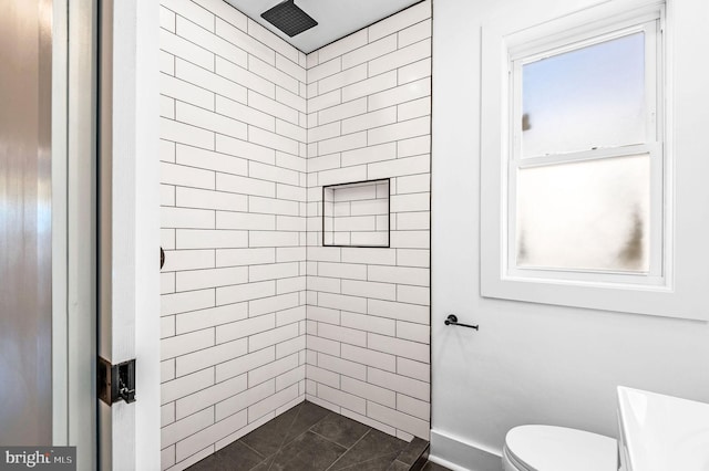 bathroom featuring toilet and tiled shower