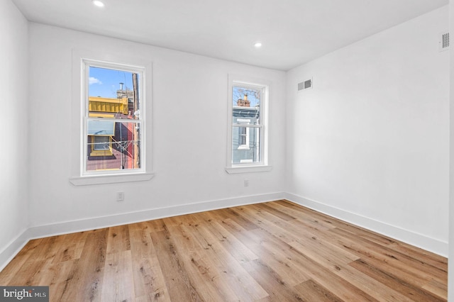 spare room featuring light wood-type flooring and a wealth of natural light