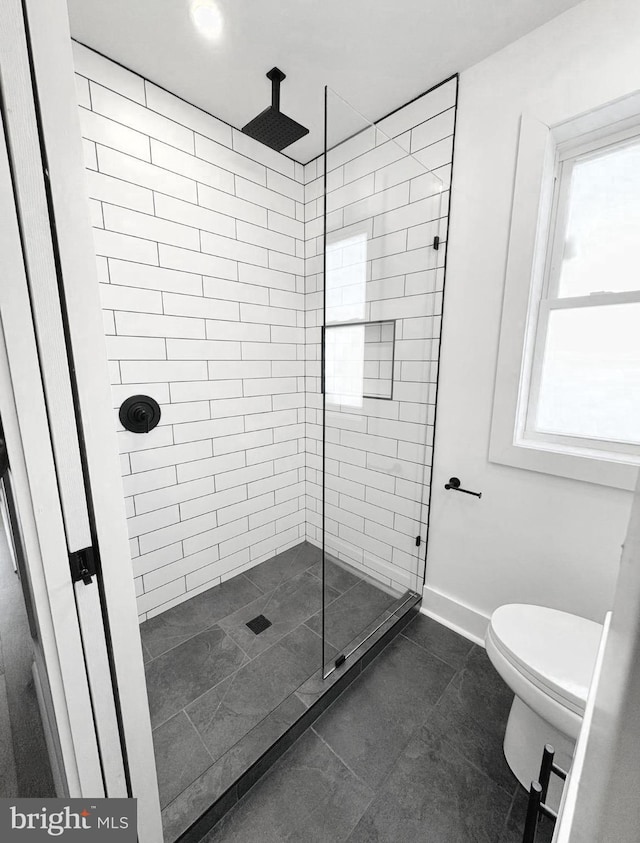 bathroom with toilet and a tile shower