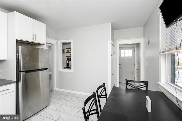 kitchen featuring white cabinetry and stainless steel refrigerator