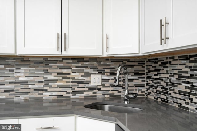 kitchen with white cabinets, sink, and backsplash