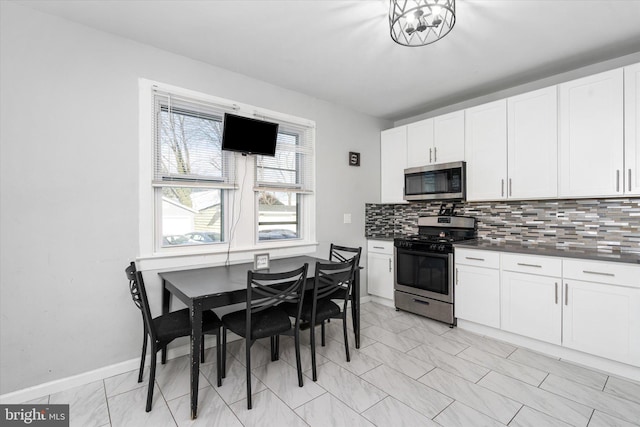 kitchen featuring tasteful backsplash, white cabinets, and appliances with stainless steel finishes