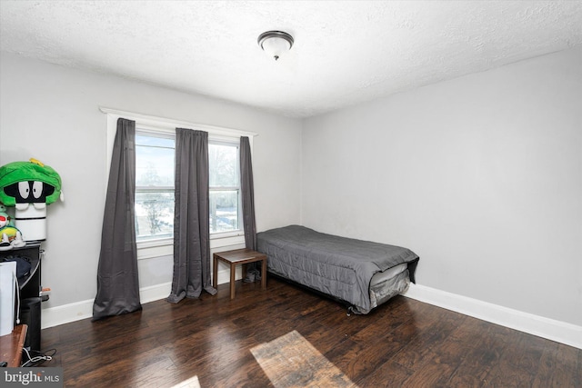 bedroom with dark hardwood / wood-style flooring and a textured ceiling