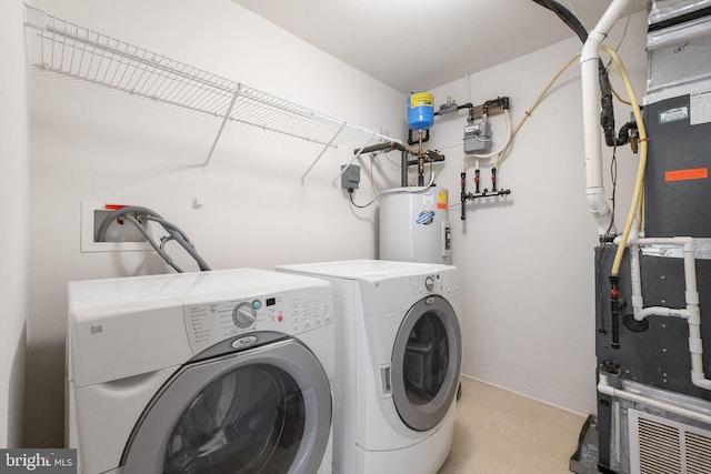 washroom with electric water heater, heating unit, and independent washer and dryer