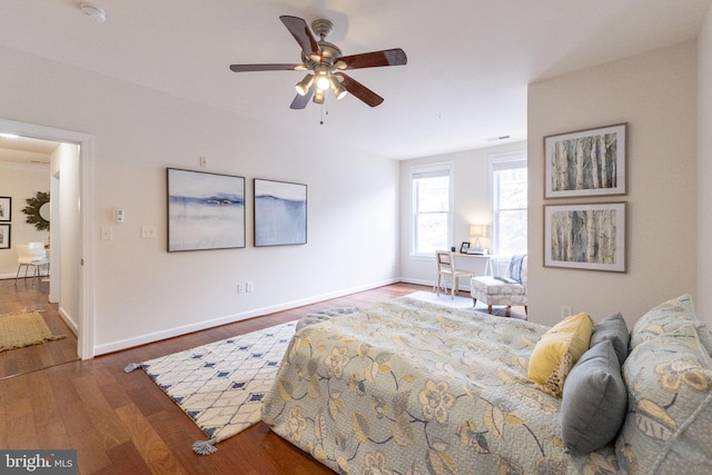 bedroom with ceiling fan and dark hardwood / wood-style flooring