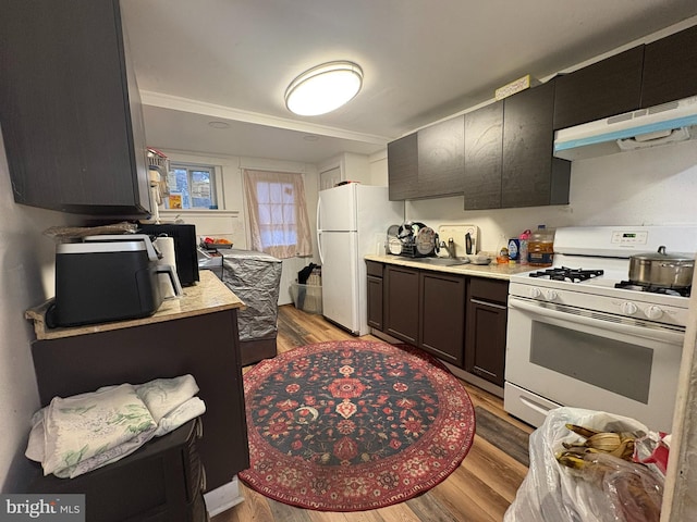 kitchen featuring light wood-type flooring, sink, and white appliances