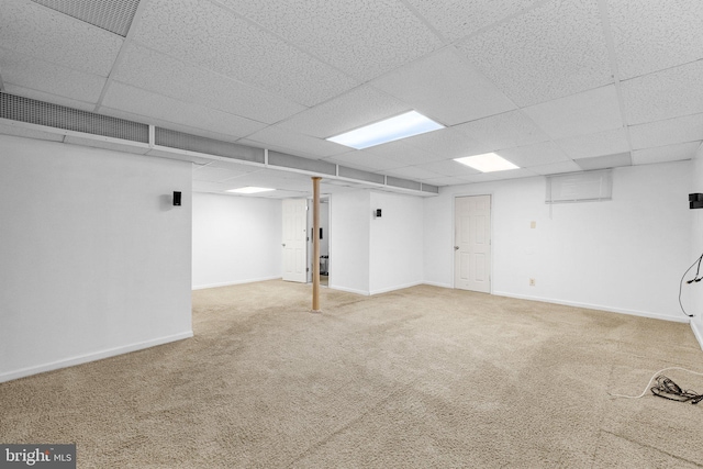 basement with a drop ceiling and carpet