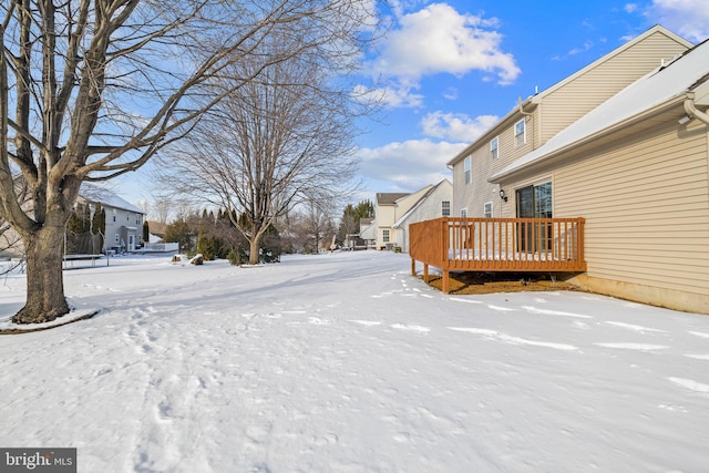 yard covered in snow with a wooden deck