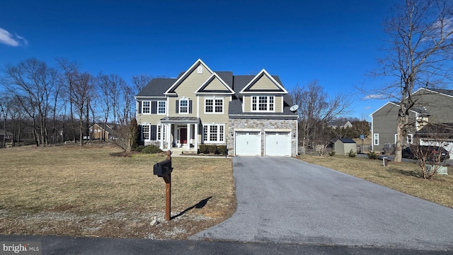 view of front facade featuring an attached garage, driveway, stone siding, and a front yard