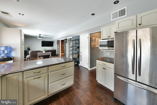 kitchen with cream cabinets, stainless steel appliances, dark hardwood / wood-style floors, and ceiling fan