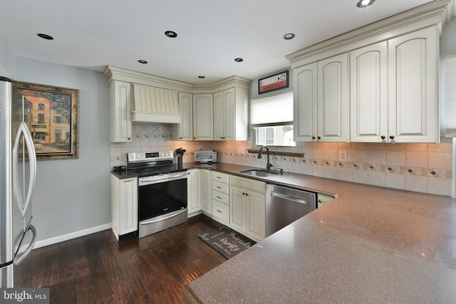 kitchen featuring stainless steel appliances, cream cabinets, sink, and custom range hood