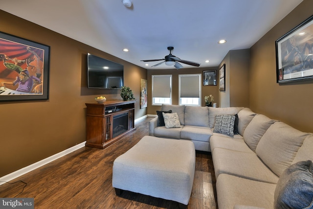 living room featuring dark wood-type flooring and ceiling fan