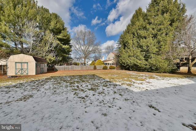 yard covered in snow with a storage shed