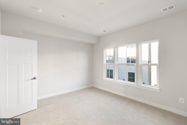 spare room featuring light colored carpet