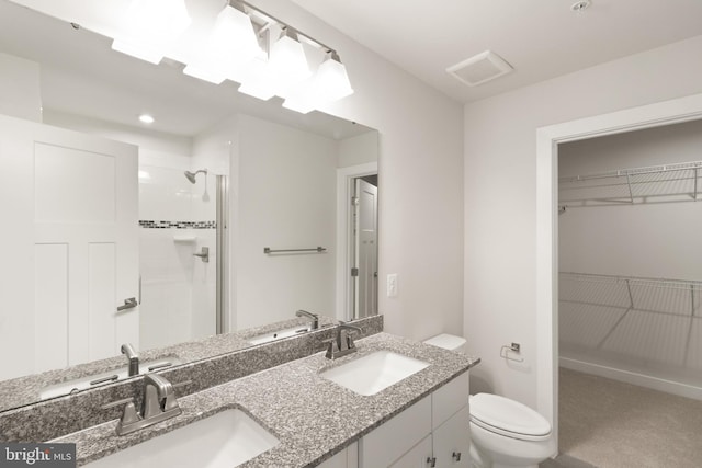 bathroom featuring vanity, toilet, and an enclosed shower