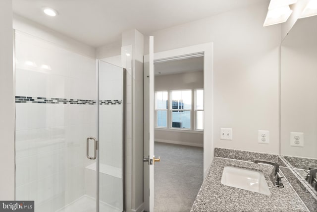 bathroom featuring an enclosed shower and vanity