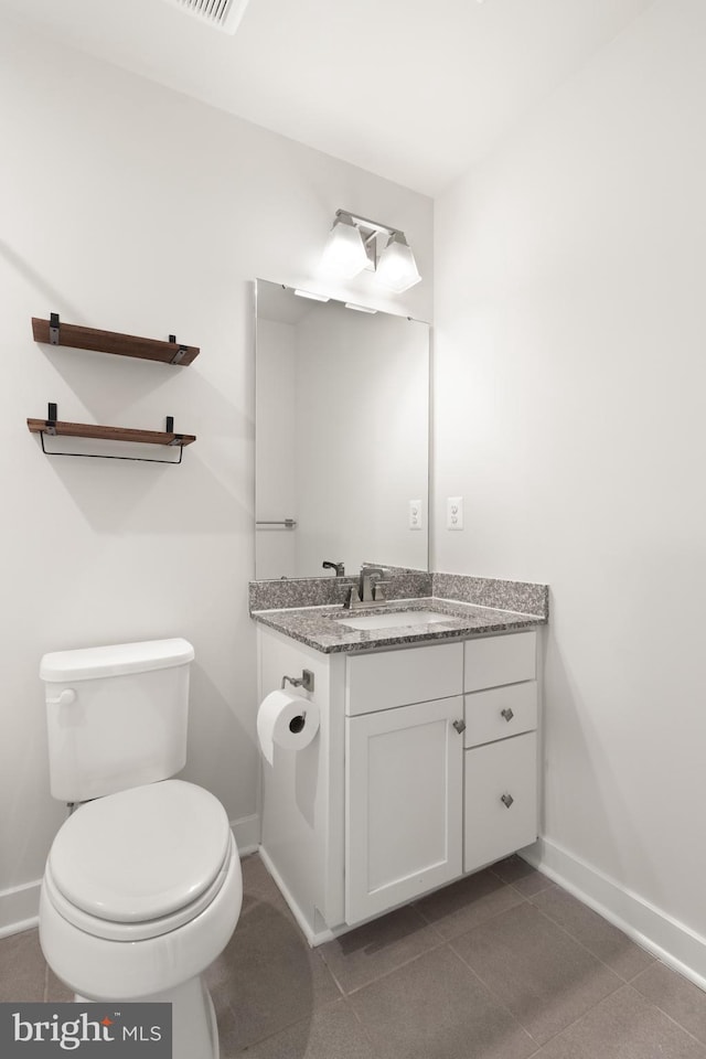 bathroom featuring toilet, vanity, and tile patterned floors