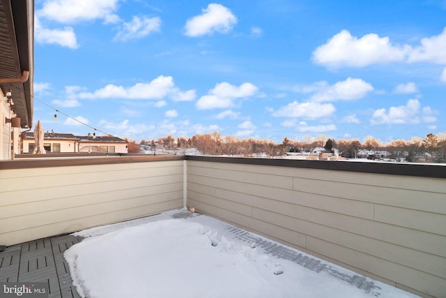 snow covered patio with a balcony