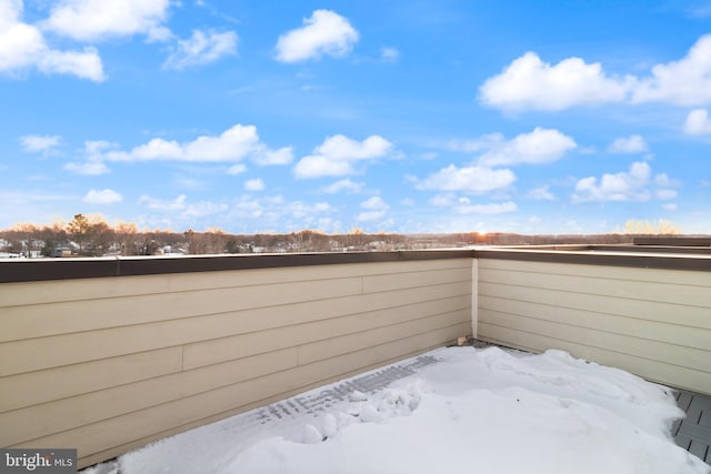 snow covered patio with a balcony