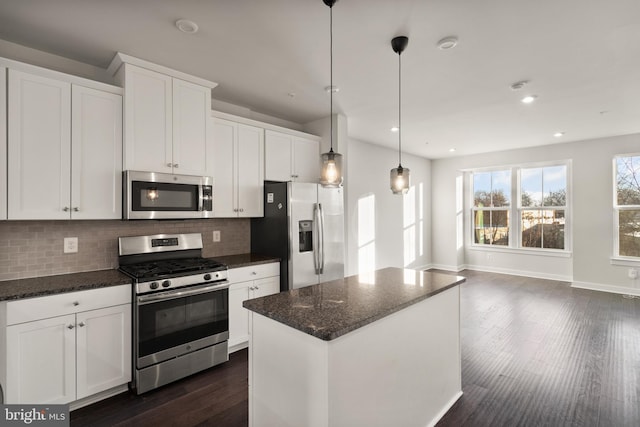 kitchen featuring tasteful backsplash, appliances with stainless steel finishes, white cabinetry, and a center island