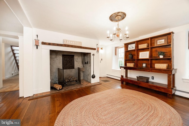 sitting room with a baseboard heating unit, an inviting chandelier, and hardwood / wood-style flooring