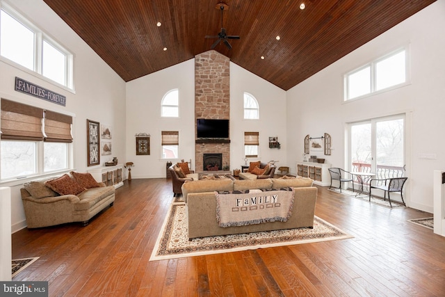 living room with a fireplace, wood-type flooring, a high ceiling, wood ceiling, and plenty of natural light