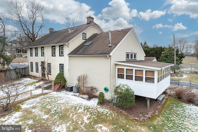 snow covered property featuring a sunroom