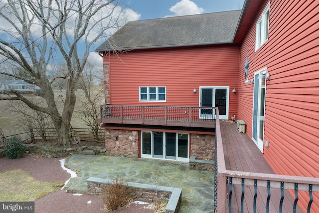 rear view of property featuring a wooden deck and a patio area