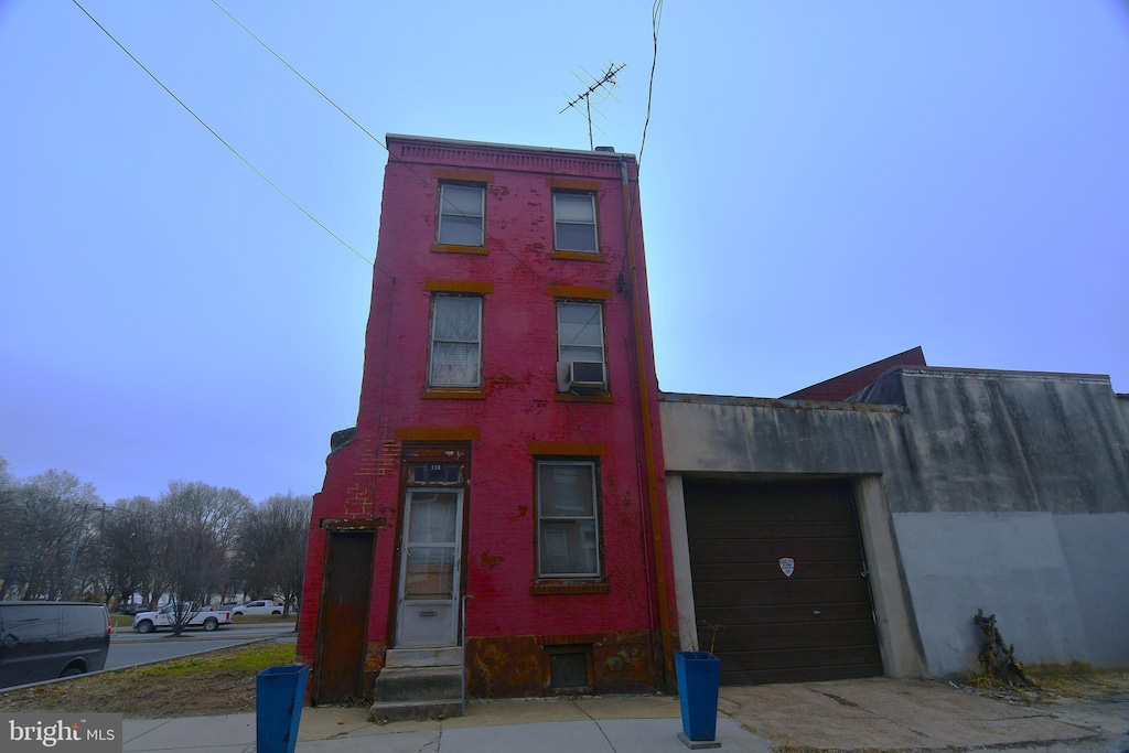 view of front of home with cooling unit and a garage