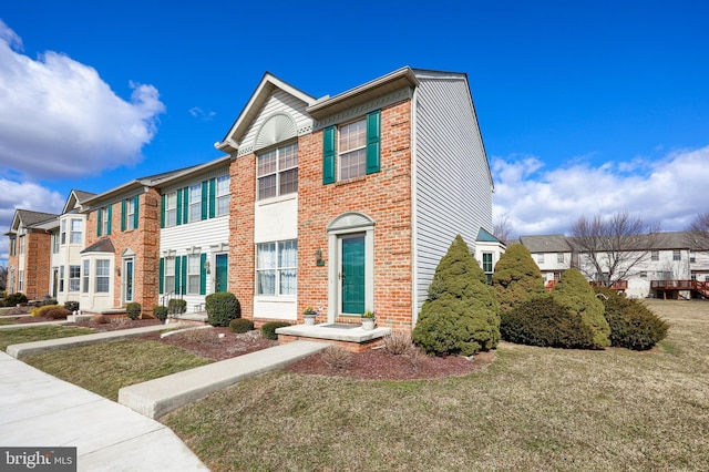 multi unit property with brick siding, a front lawn, and a residential view