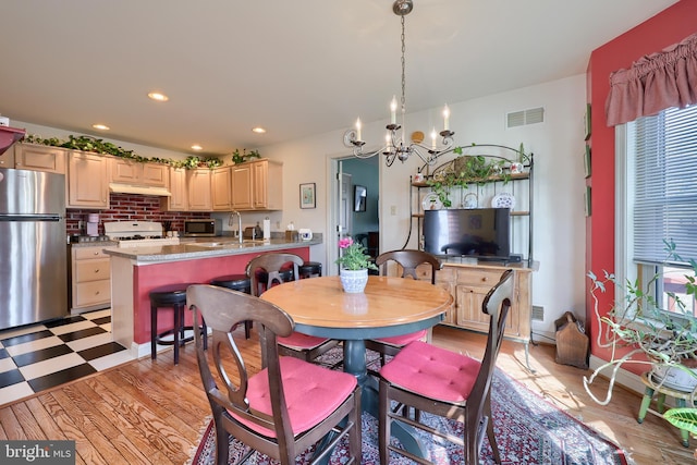 dining area with a wealth of natural light, light wood-style floors, visible vents, and recessed lighting