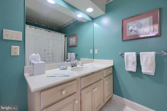 full bathroom with vanity and baseboards