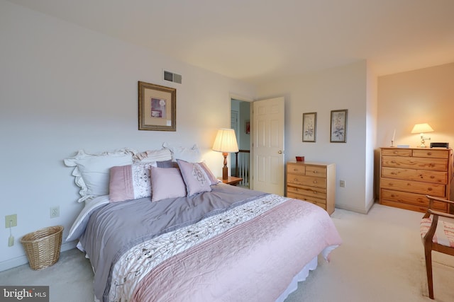 bedroom with light carpet, visible vents, and baseboards