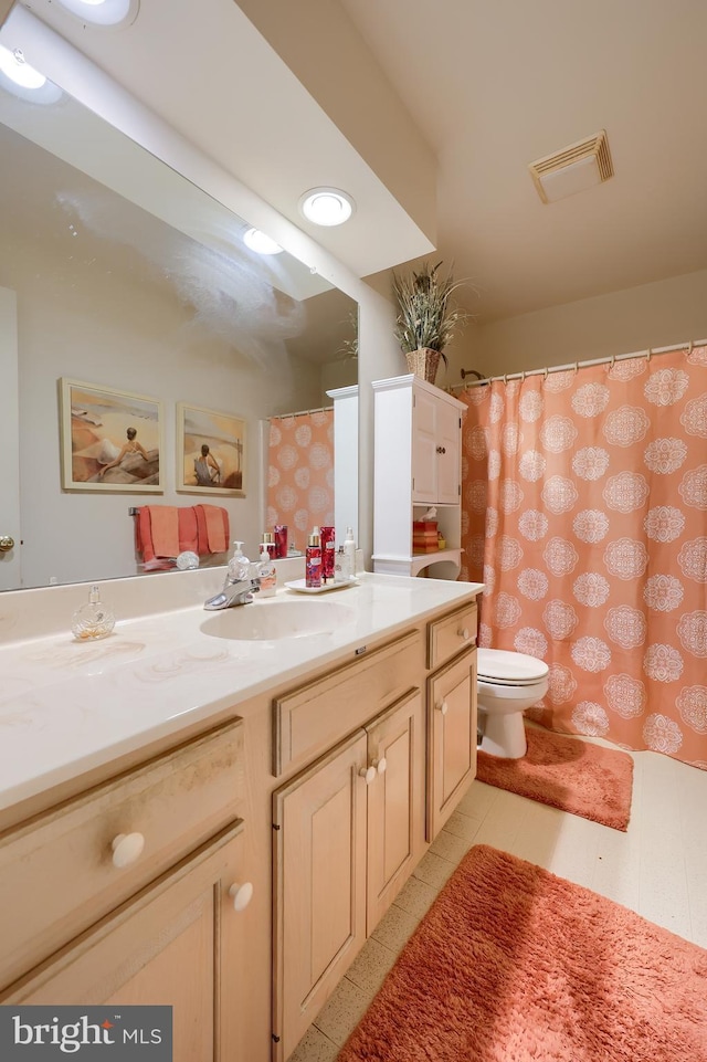 full bathroom with toilet, visible vents, and vanity