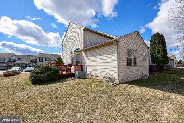 view of side of home with central AC, a lawn, and a deck