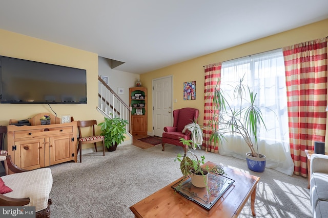 living room featuring carpet floors and stairway