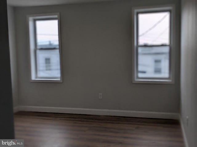 unfurnished room with dark hardwood / wood-style flooring