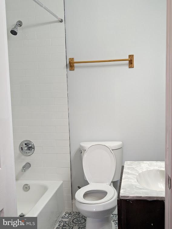 full bathroom featuring toilet, vanity, and tiled shower / bath combo