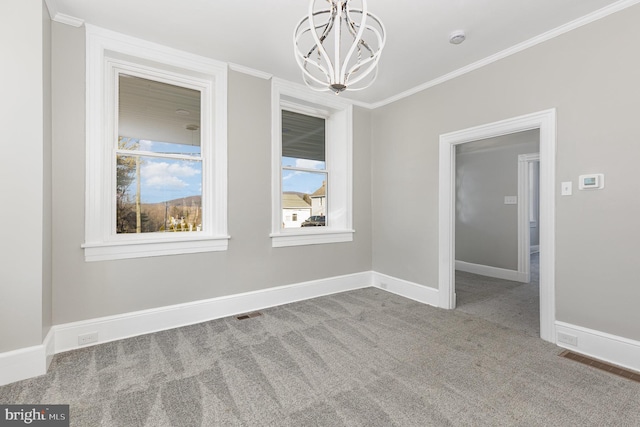 spare room with carpet floors, ornamental molding, and an inviting chandelier