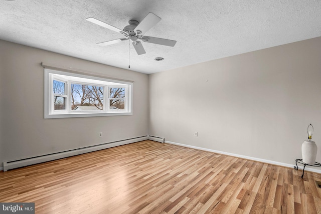 unfurnished room with a textured ceiling, baseboard heating, and light hardwood / wood-style flooring