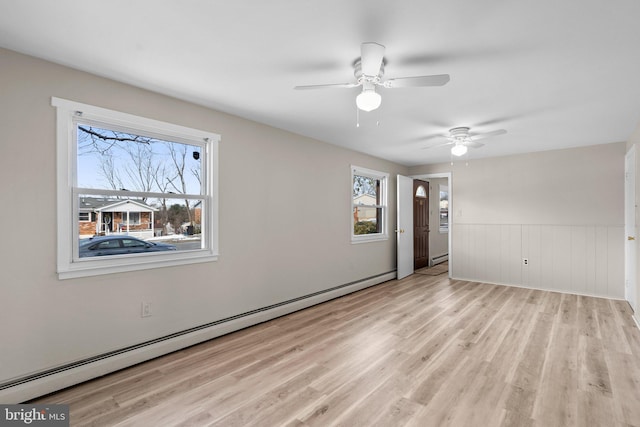 unfurnished room featuring light hardwood / wood-style flooring and a baseboard heating unit