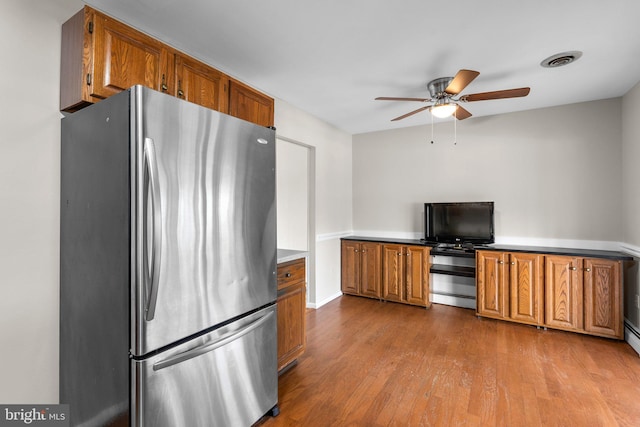 kitchen with stainless steel fridge, light hardwood / wood-style floors, and ceiling fan