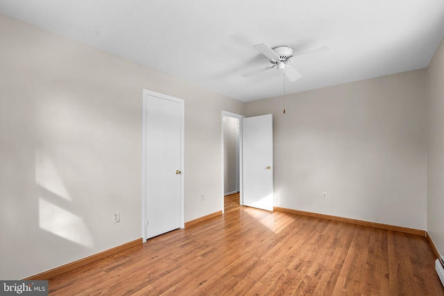 unfurnished bedroom with a baseboard heating unit, ceiling fan, and light hardwood / wood-style flooring