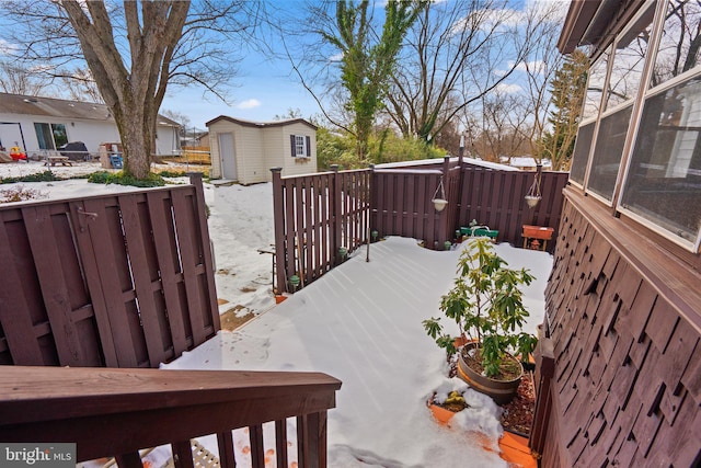 snow covered deck featuring a storage shed