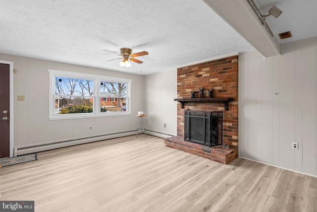 unfurnished living room with ceiling fan, a baseboard heating unit, a textured ceiling, a brick fireplace, and light wood-type flooring