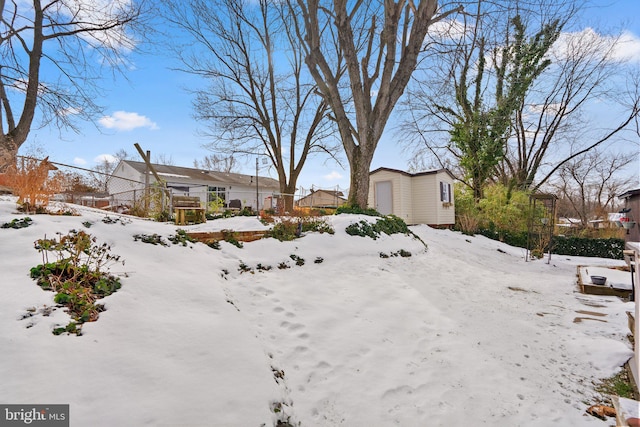 yard covered in snow featuring a storage shed