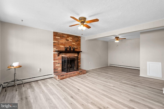 unfurnished living room with a baseboard radiator, light wood-type flooring, a textured ceiling, and a fireplace