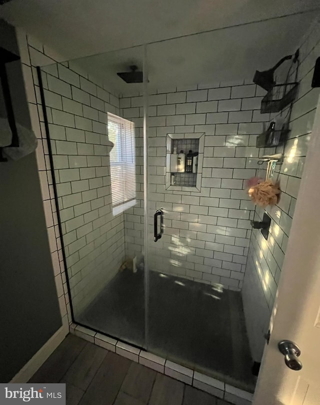 bathroom featuring hardwood / wood-style floors and a shower with shower door