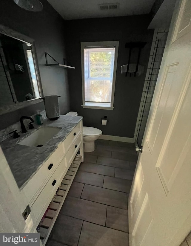 bathroom featuring vanity, tile patterned floors, and toilet